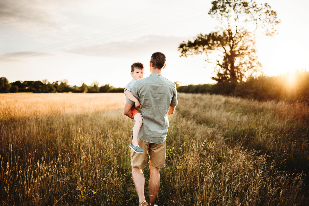 other carrying his son during sunset