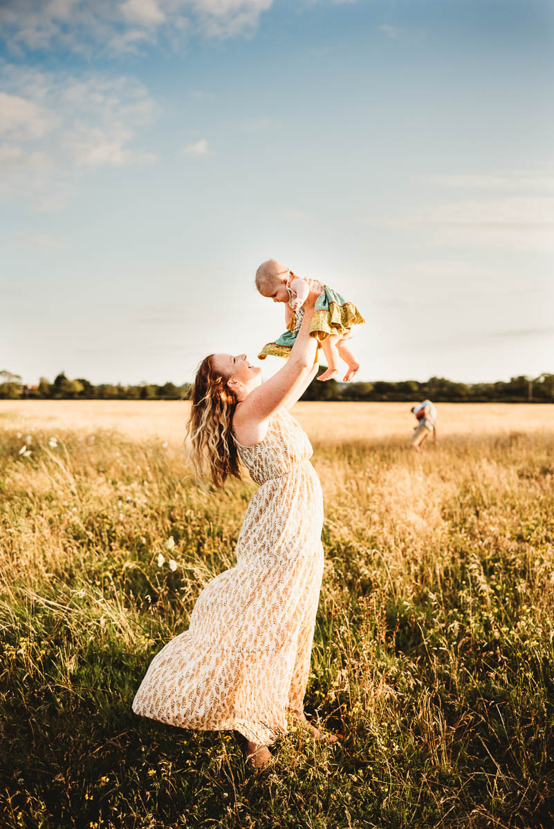 A mother holding her baby up to the sky