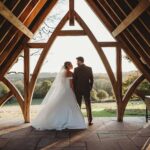 bride and groom standing under the arch in the grounds of Highley Manor