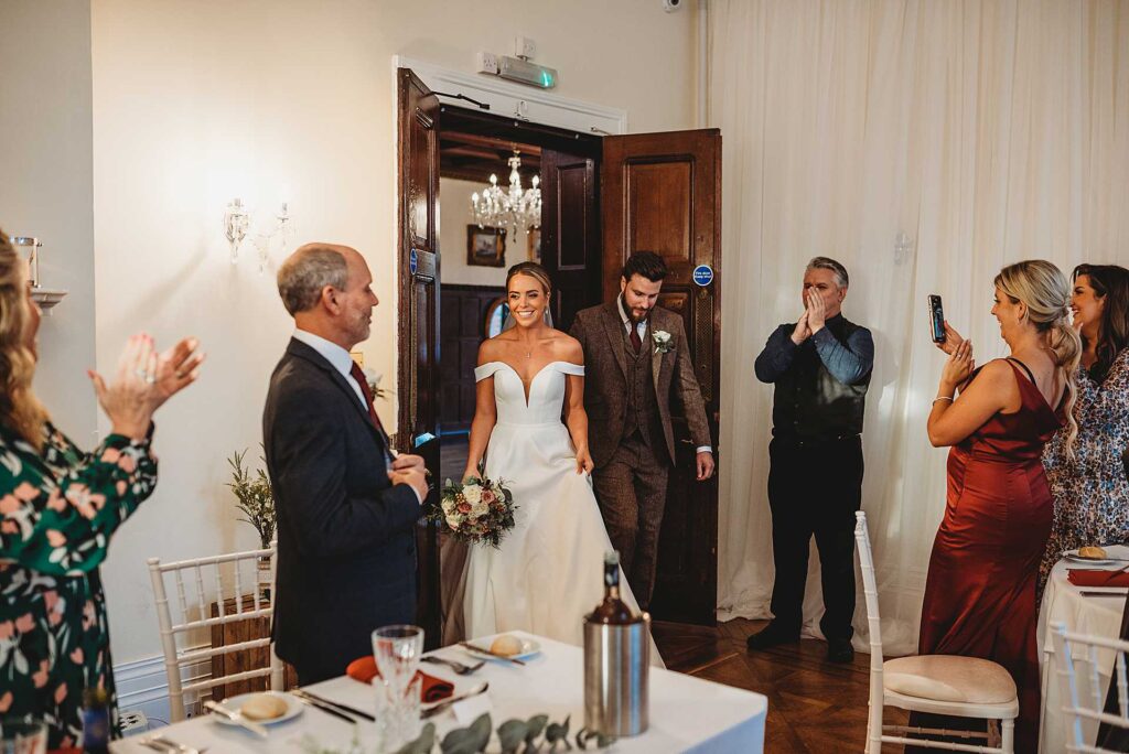 bride and groom walking into the wedding wedding breakfast room