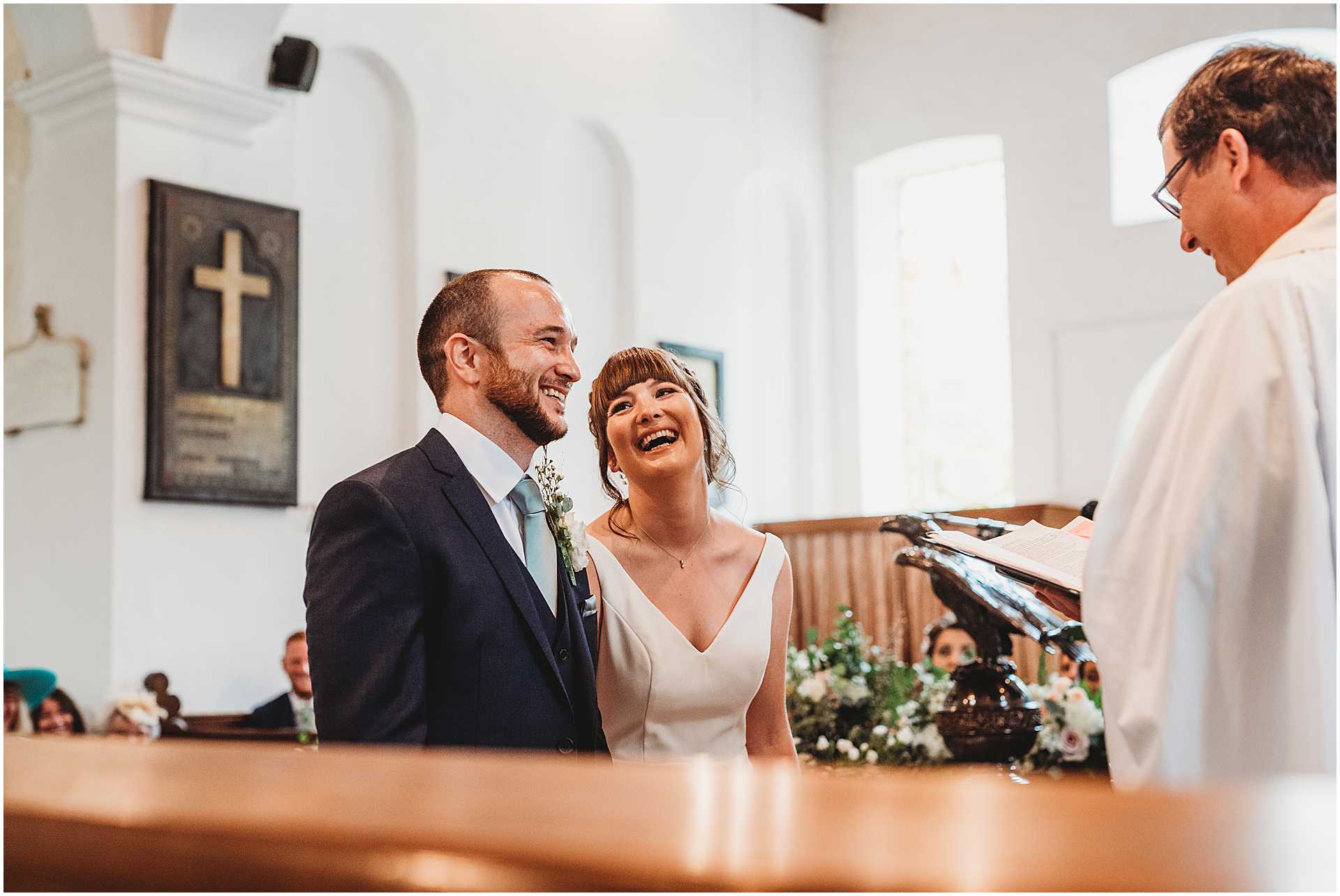 bride and groom laughing during their church ceremony at hale park