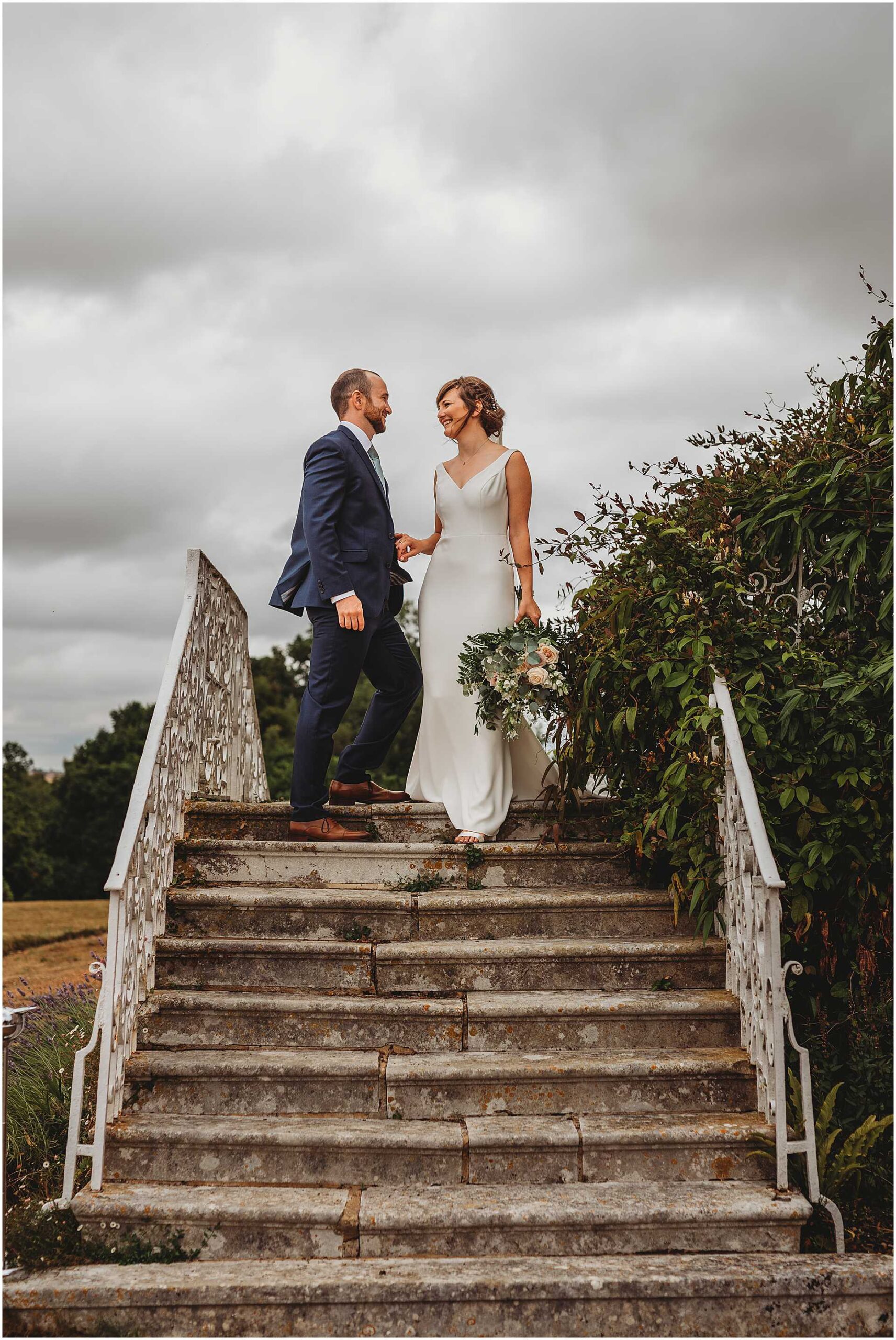 bride and groom standing on the back steps at hale park