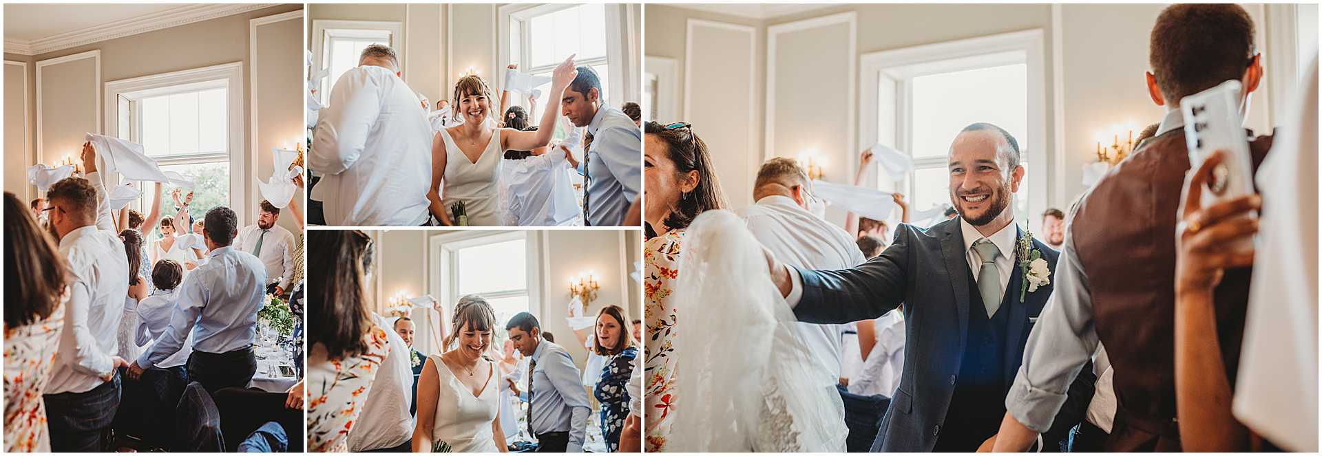 bride and groom entering the wedding breakfast as guests clap and cheer