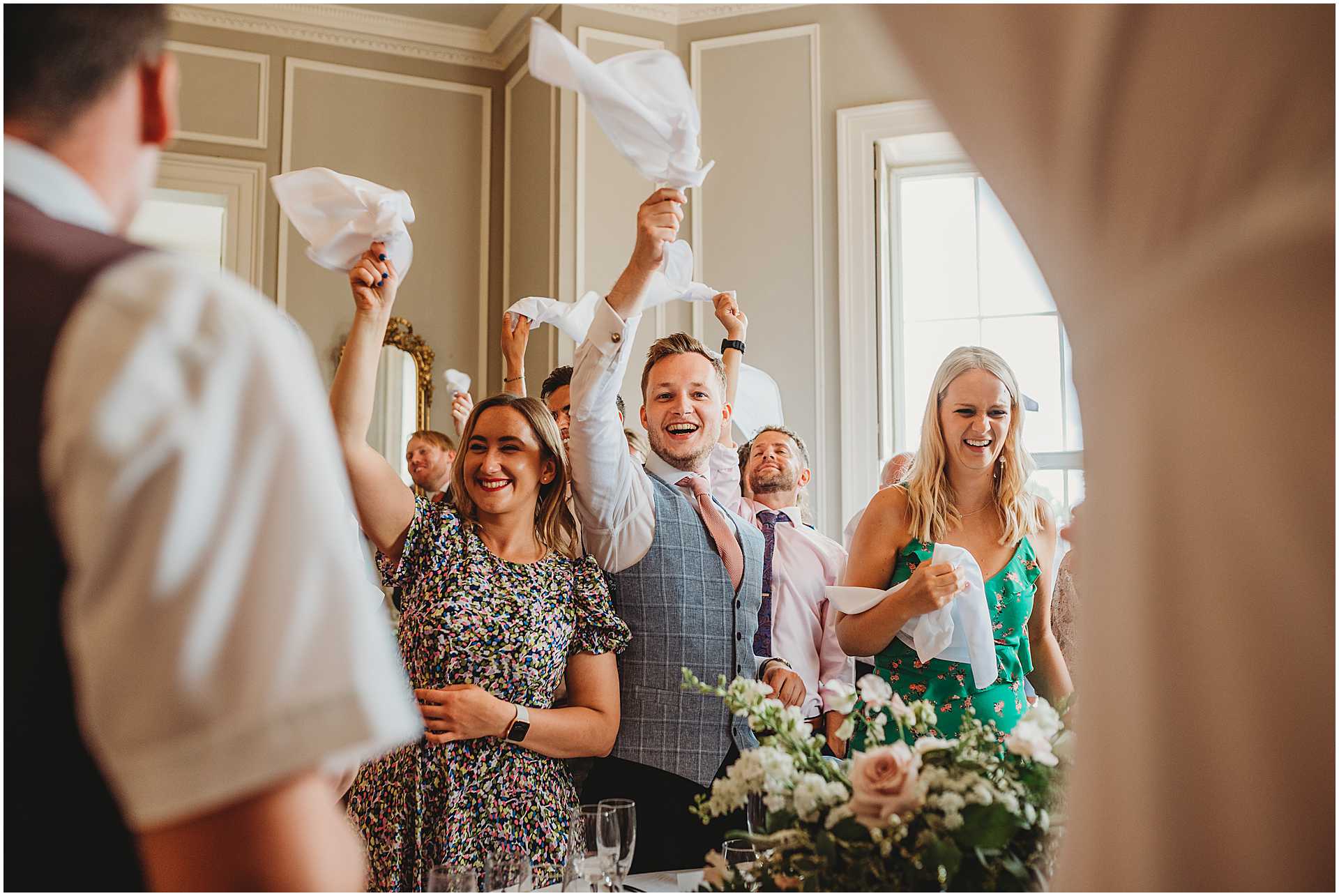 guests waving napkins in the air as bride and groom ever the wedding breakfast