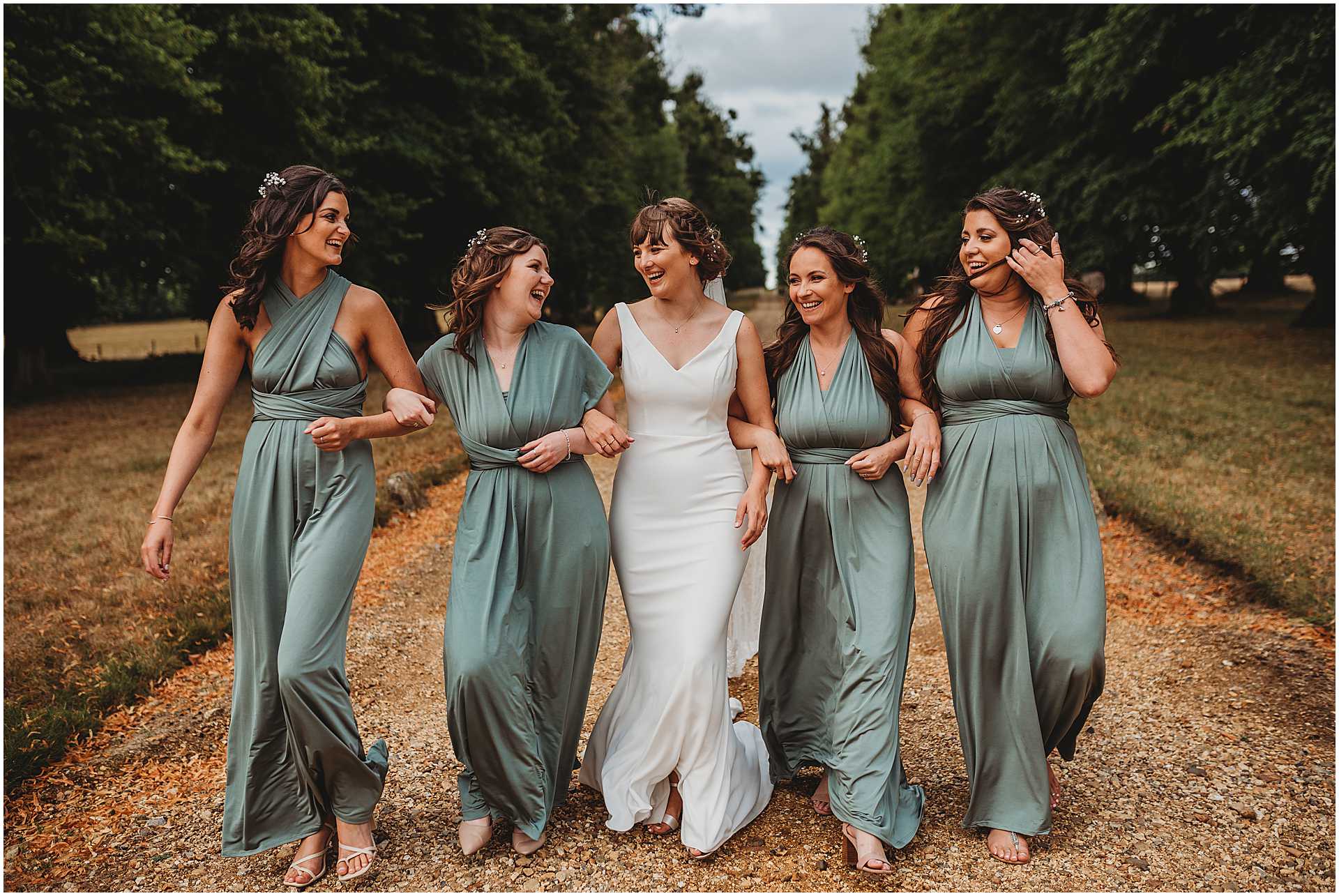 bride and her bridesmaid walking together on the driveway of hale park wedding venue