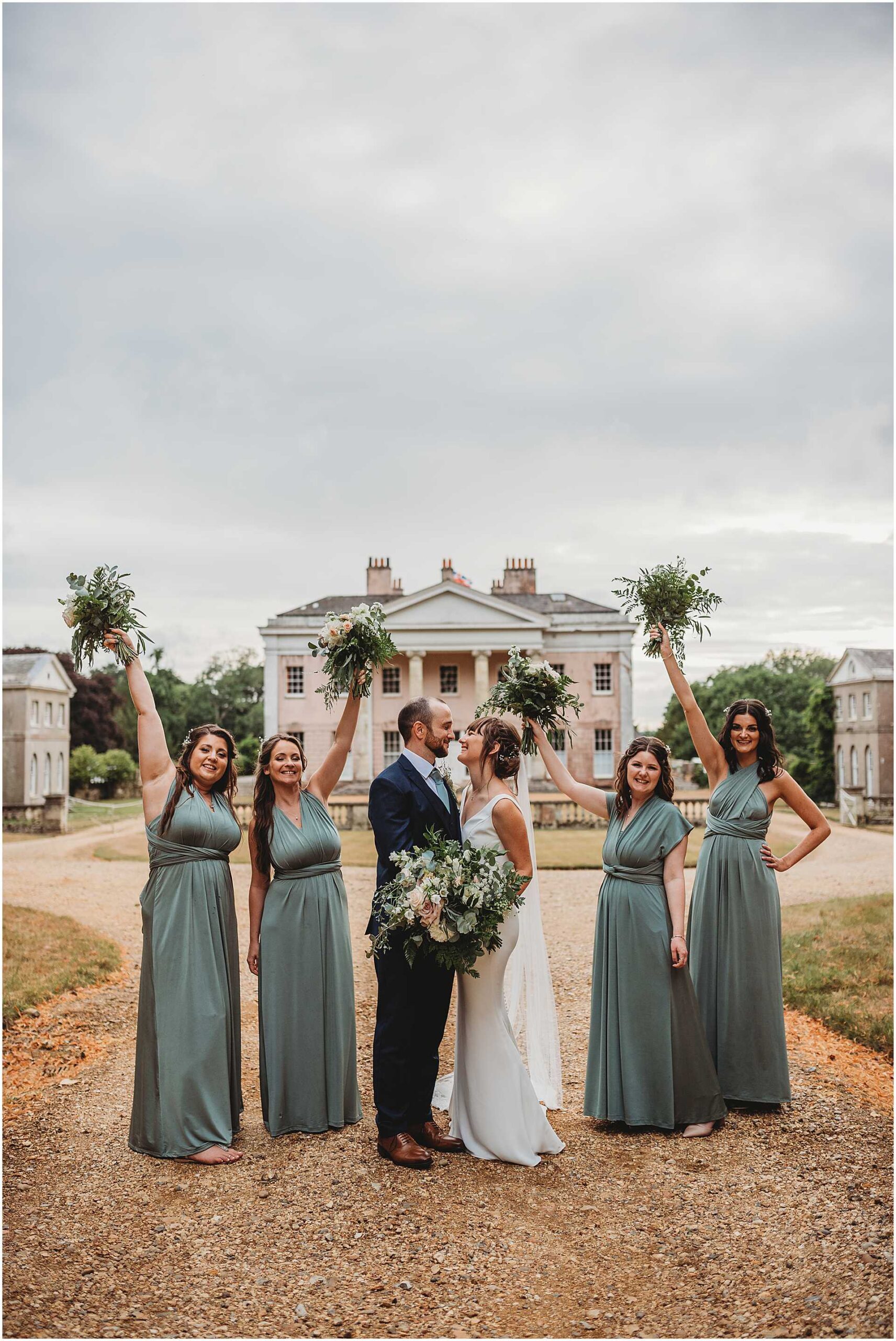 bride and groom on the driveway at hale park with their bridesmaids