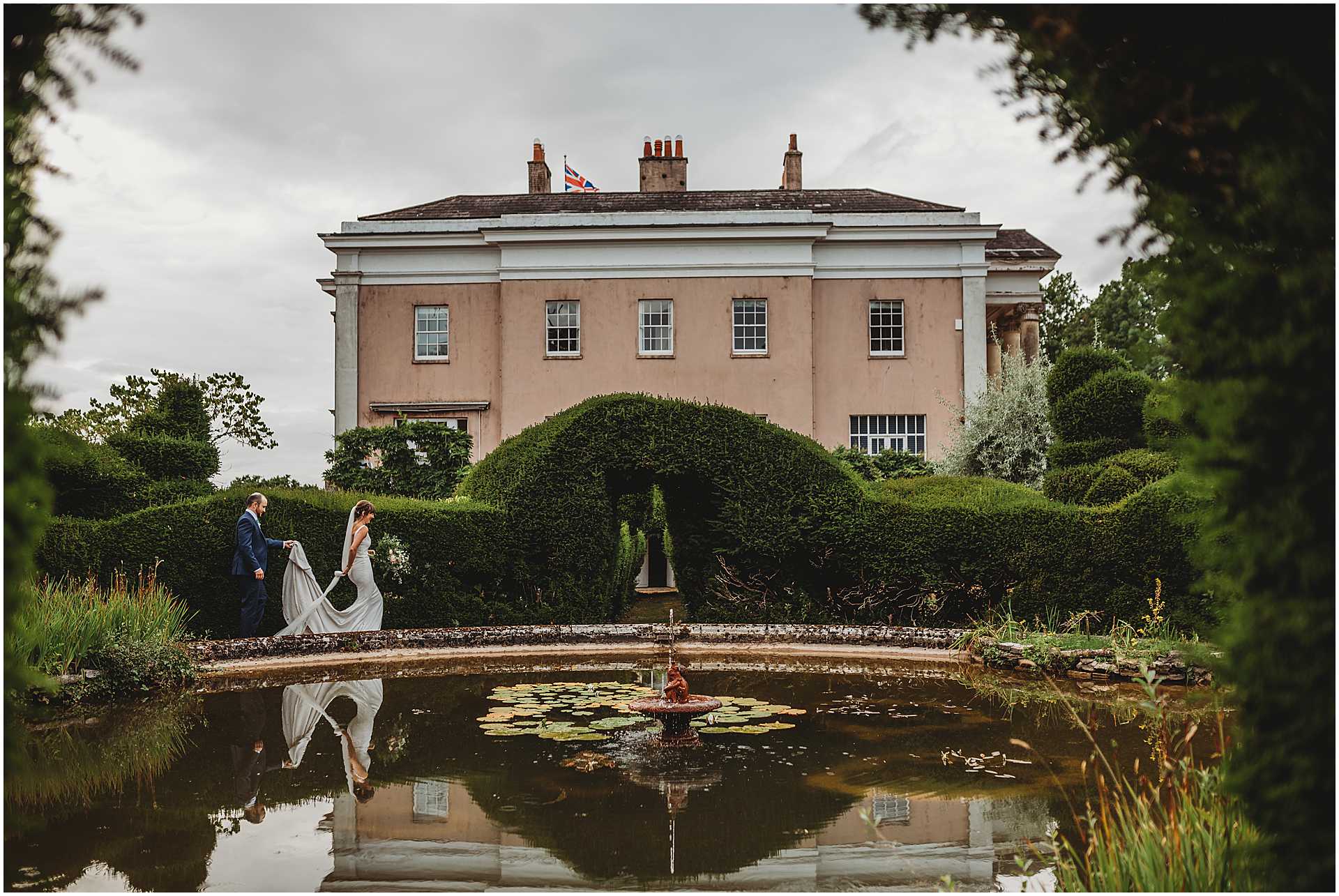 bride and groom walking by the pond at hale park