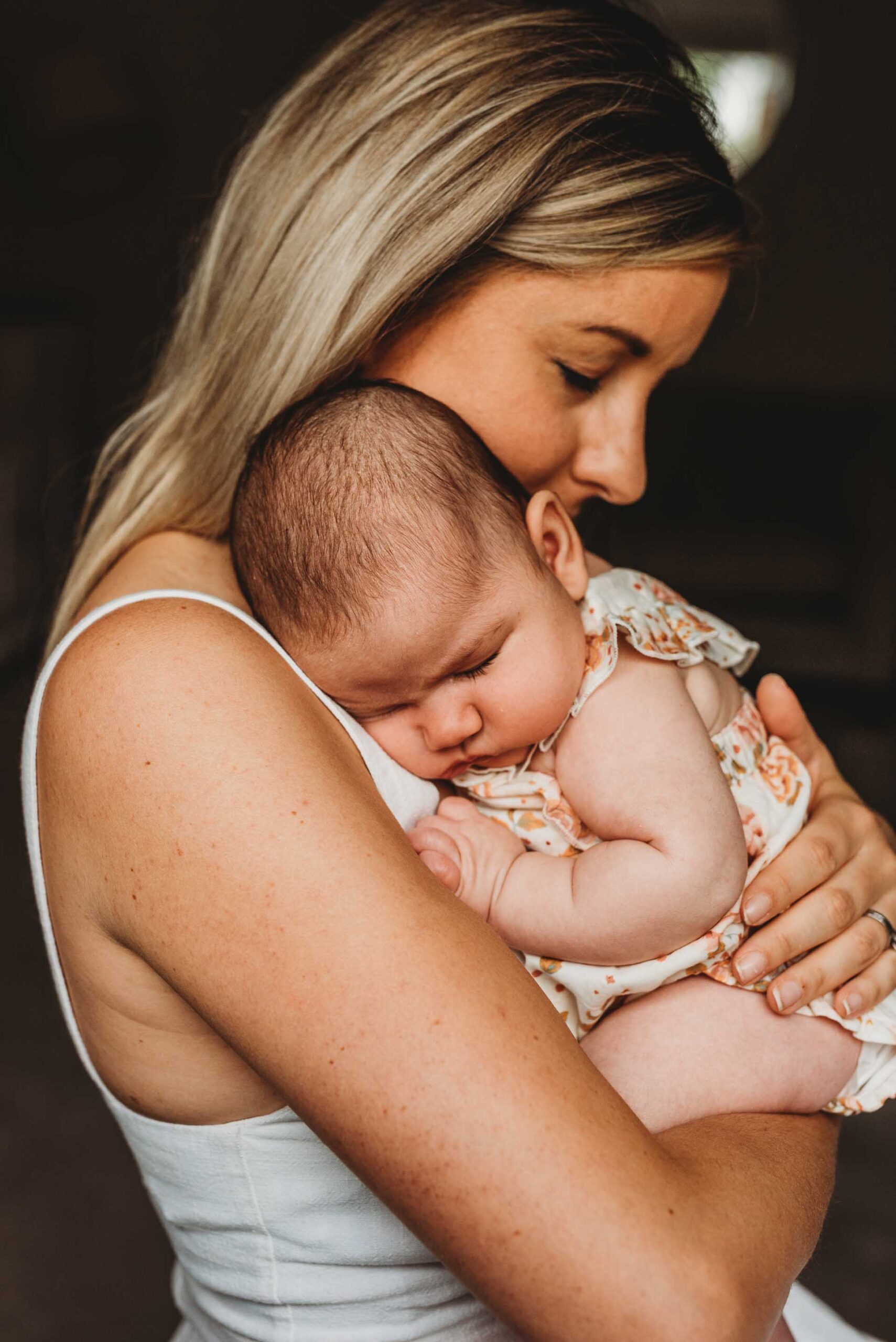 woman holding her sleeping baby on her chest