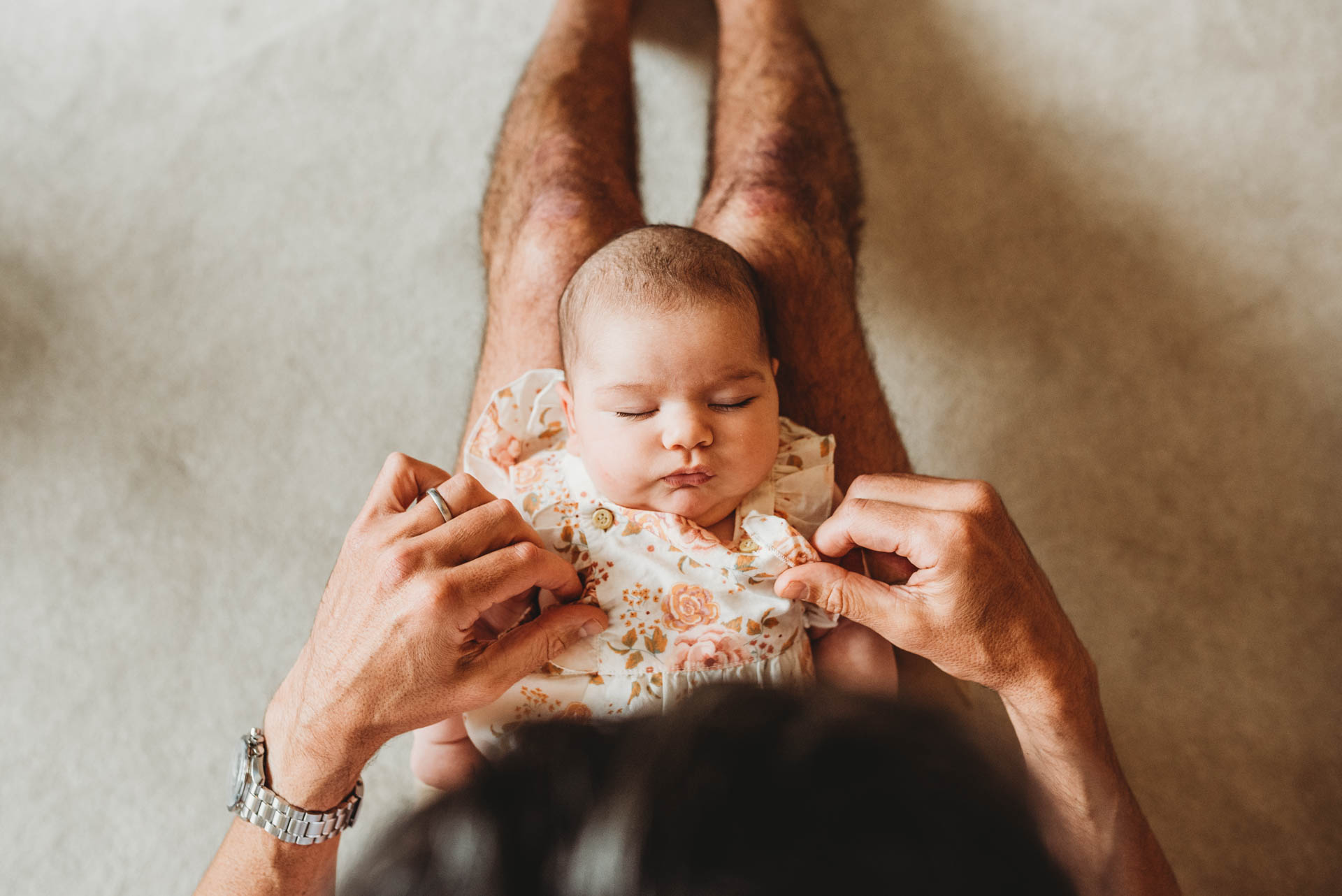 man looking down at sleeping baby