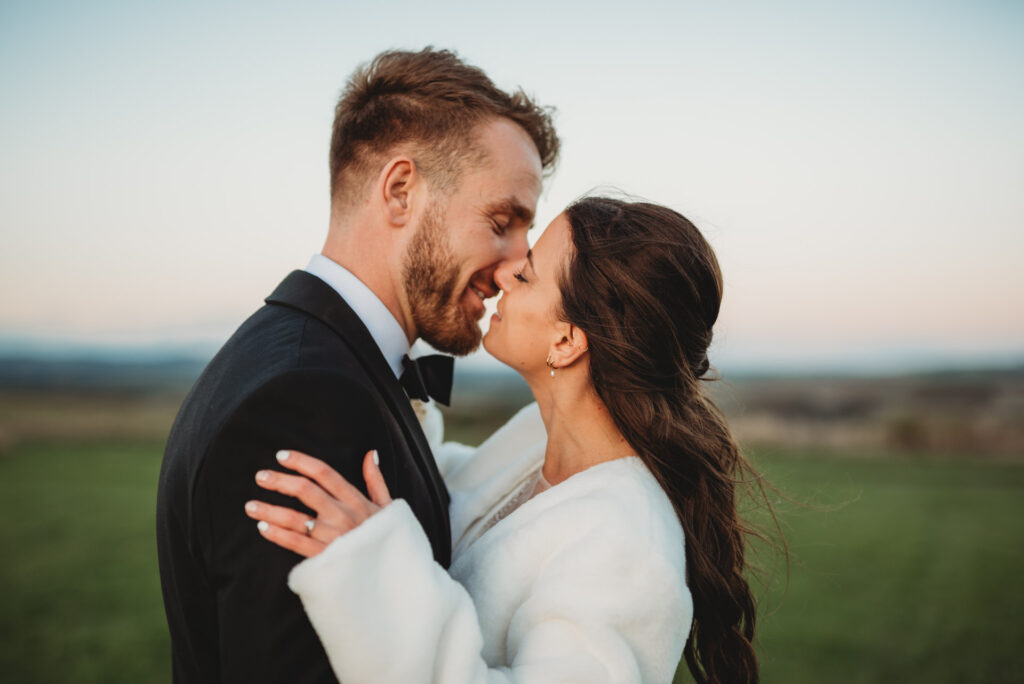 wedding at chalk barn showing the bride and groom kissing outdoors by Wedding Photographer in Wiltshire, the Cotswolds, Gloucestershire and beyond.