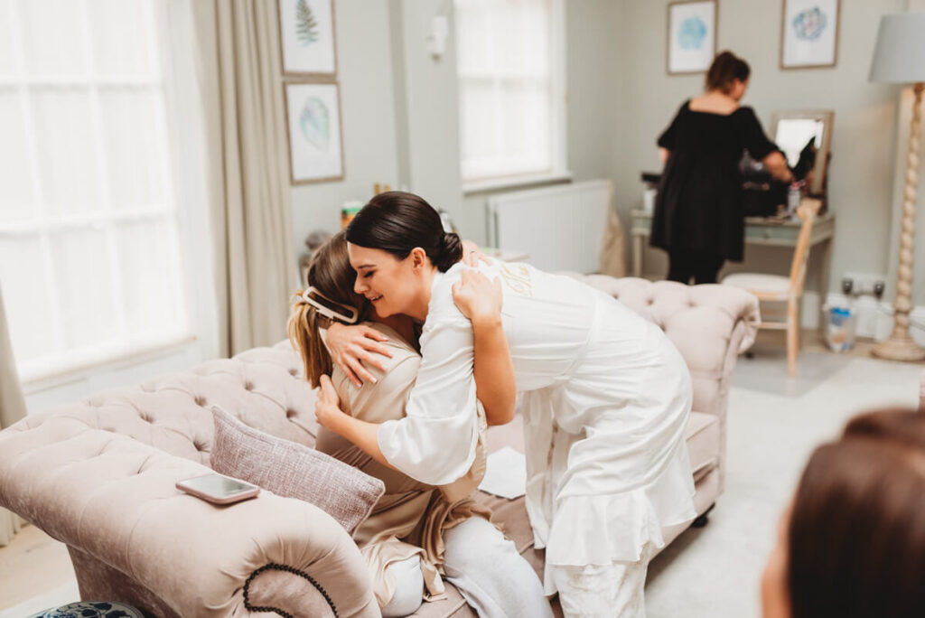 bride and maid of honour sharing a hug during the bridal prep
