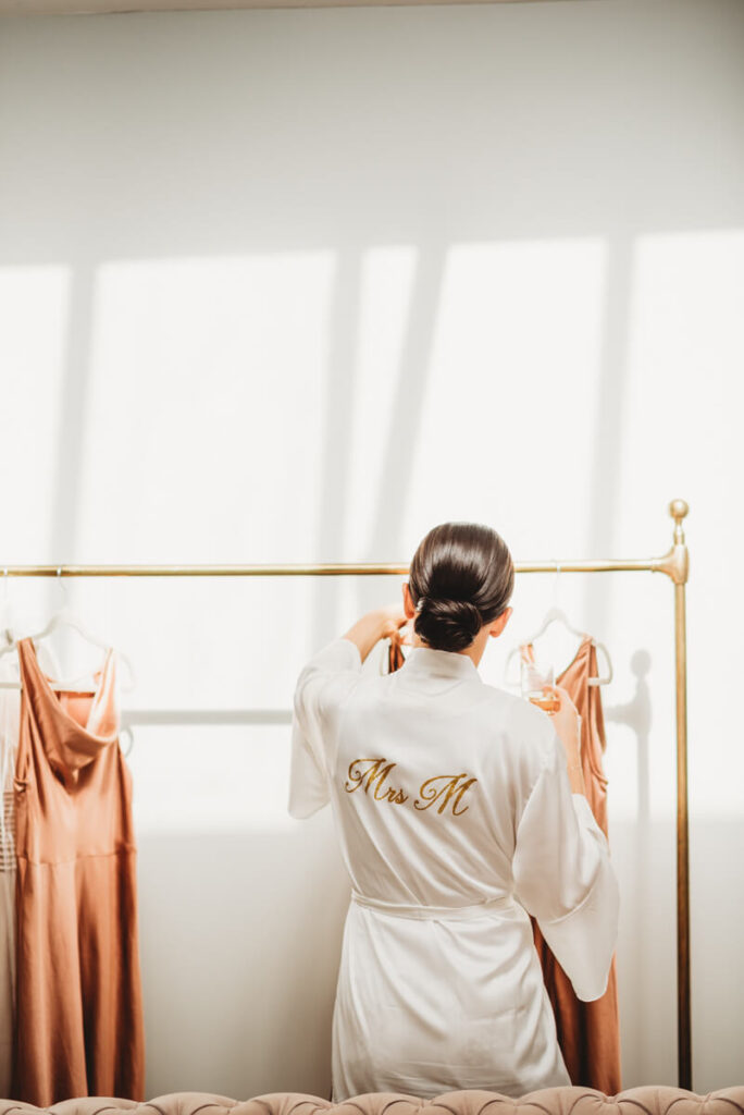 bride sorting hanging up bridesmaids dresses