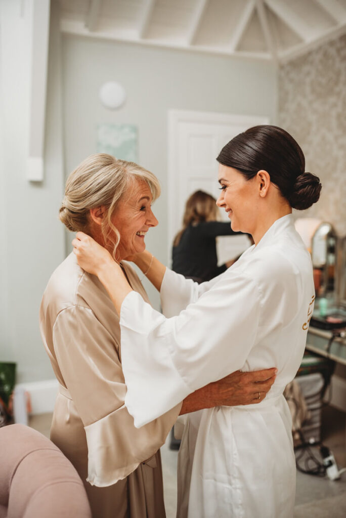 bride and mother of the bride sharing a moment during bridal prep by Wedding Photographer in Wiltshire