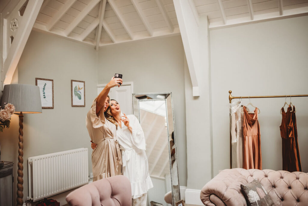 bridesmaids taking selfies during bridal prep at Syrencot house