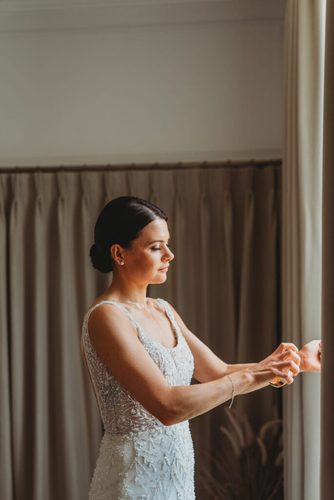 bride spraying her perfume on