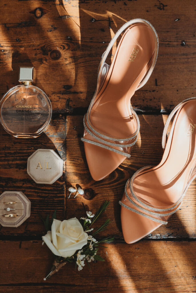 bridal details including shoes, perfume, the rings and a button hole