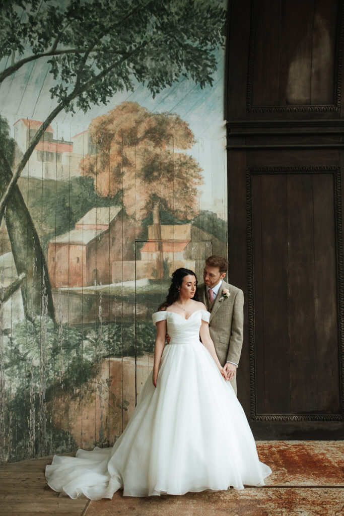 bride and groom standing in the singing theatre during the rain at Larmer Tree Gardens