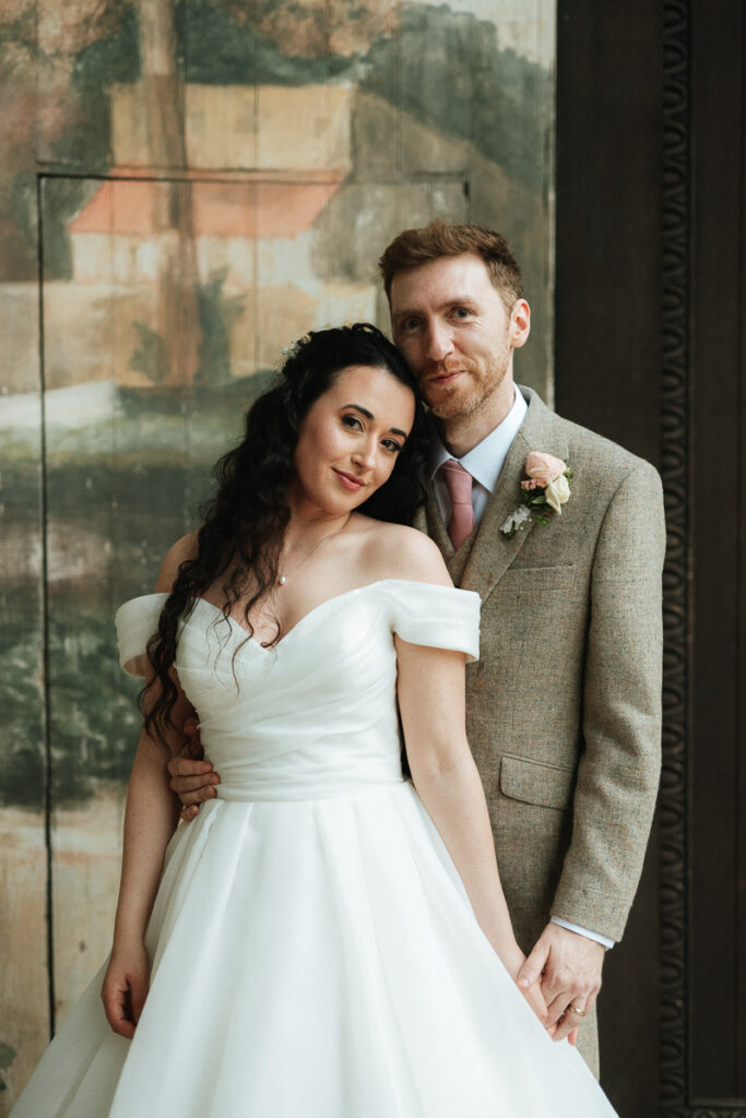 bride and groom standing in the singing theatre during the rain at Larmer Tree Gardens