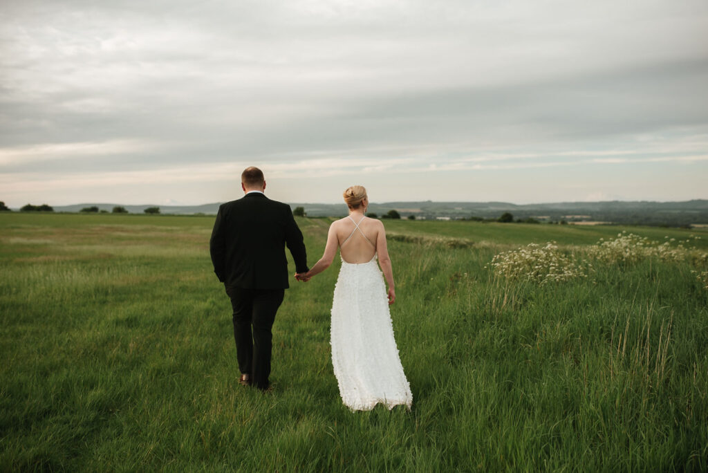 Bride and groom walking together during a short wedding photography timeline in Gloucestershire