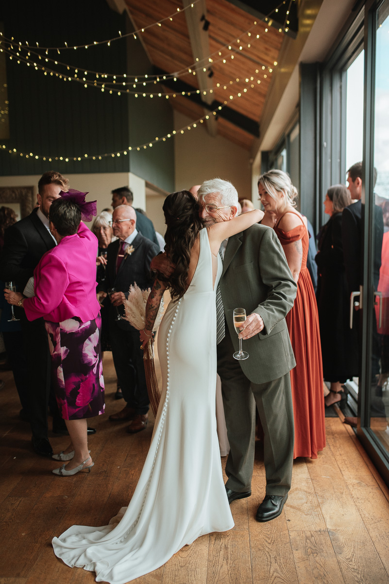 Bide hugging her grandad after micro wedding service at chalk barn in Wiltshire