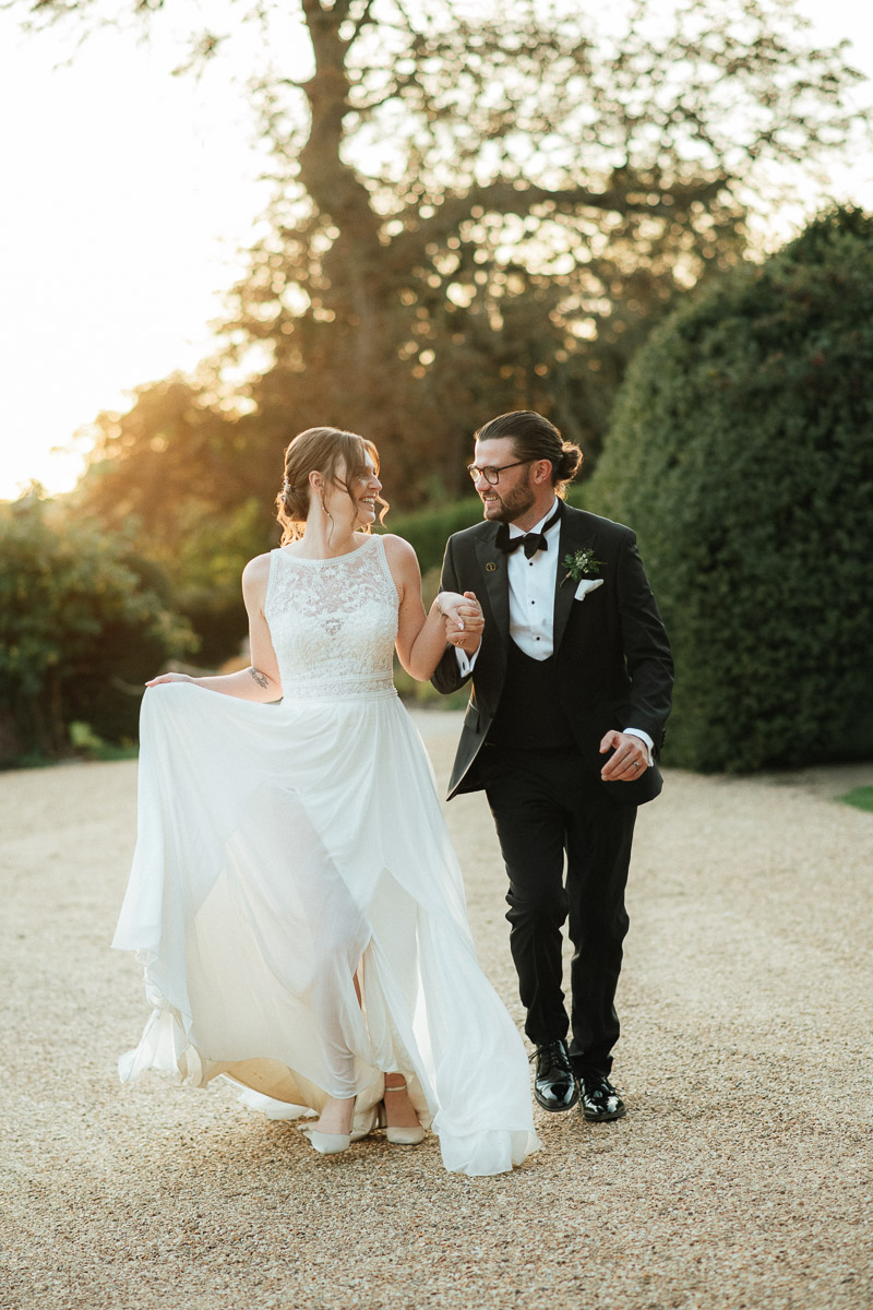 romantic bride and groom running together at golden hour, intimate wedding photography with soft natural light.