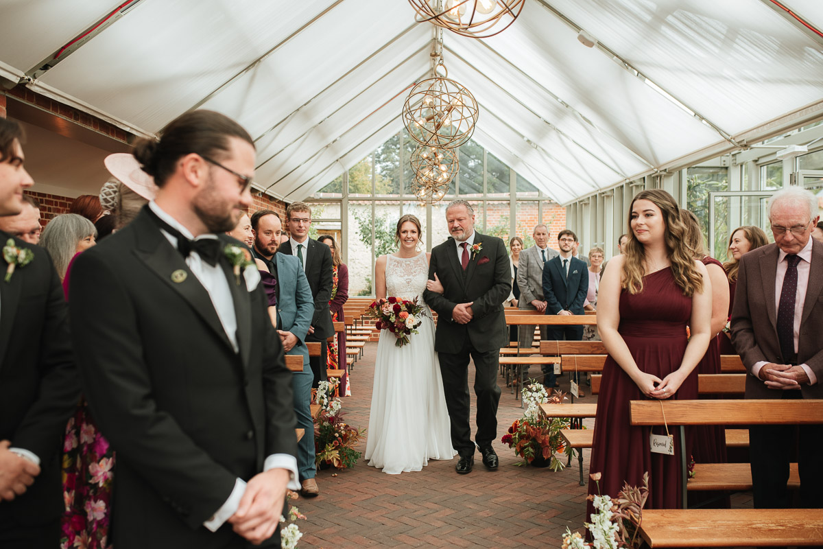 bride and dad walking up the aisle at syrencot house wedding venue