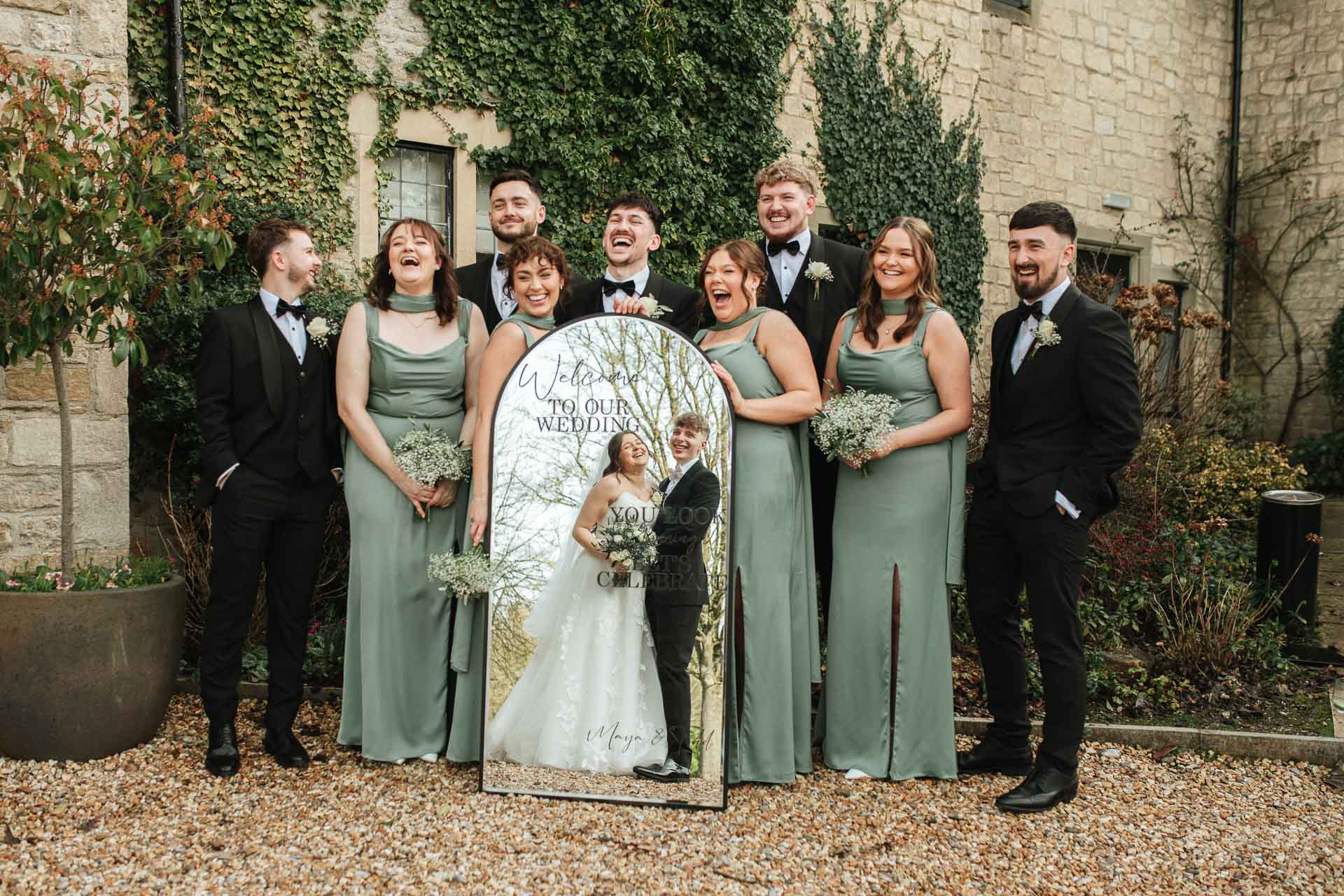 Bridal party holding a mirror with reflection of bride and groom in at the pear tree purton