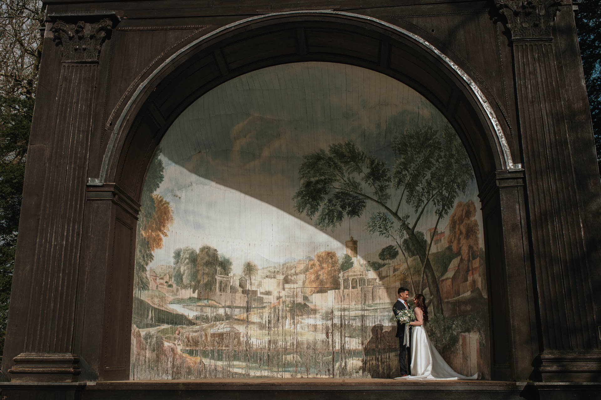 bride and groom standing together kissing in the pavilion at the Larmer Tree Gardens