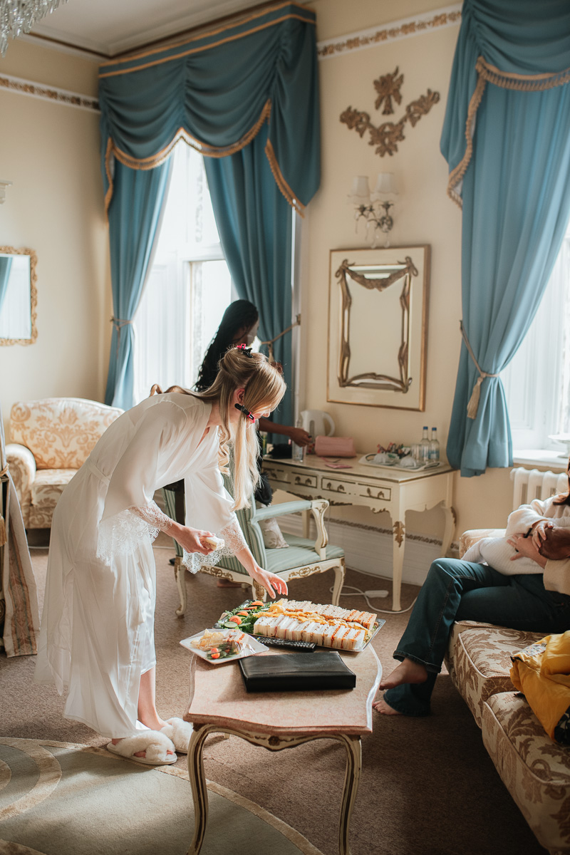 bride picking food off the platter in the bridal suite at orchardleigh estate