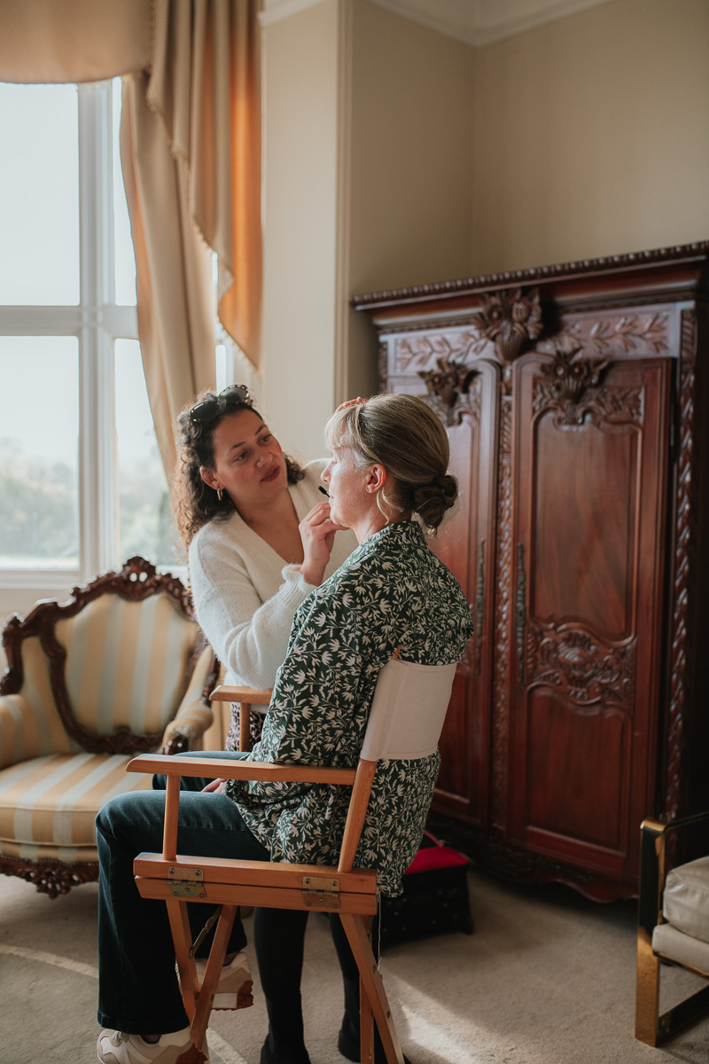mother of the bride having her makeup done in the bridal suite at orchardleigh estate