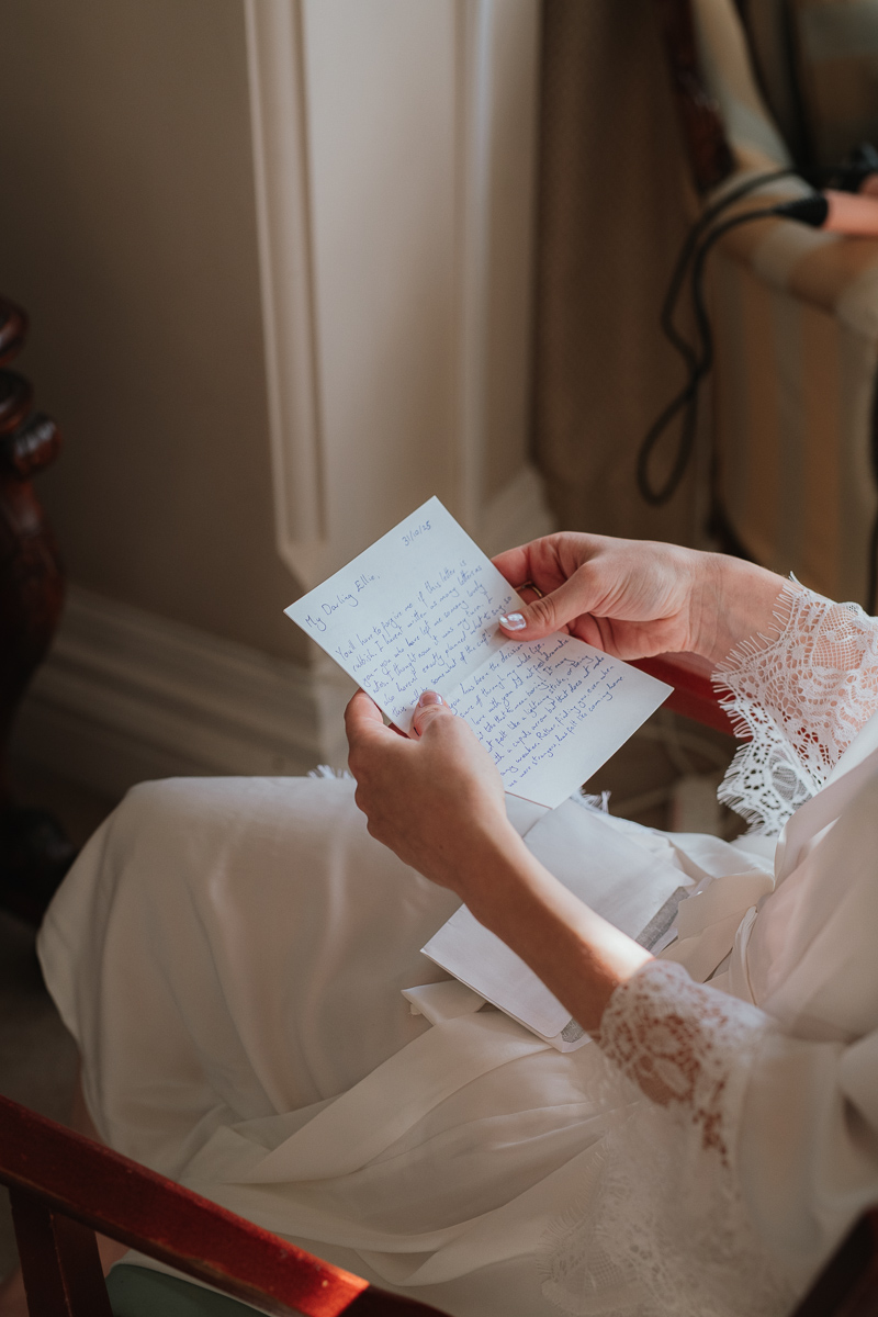 bride reading a letter from her groom at orchardleigh estate wedding venue