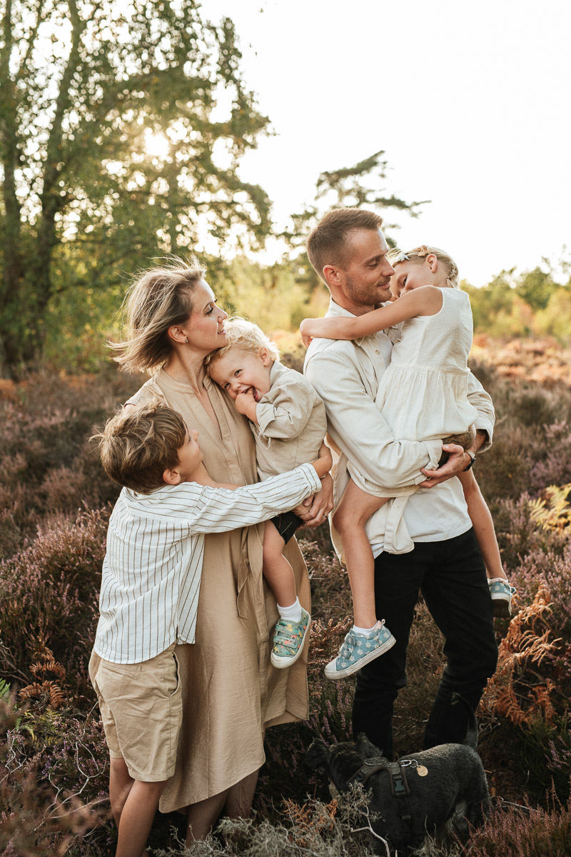 parents and their 3 children standing in the heather at snelsmore common during sunset