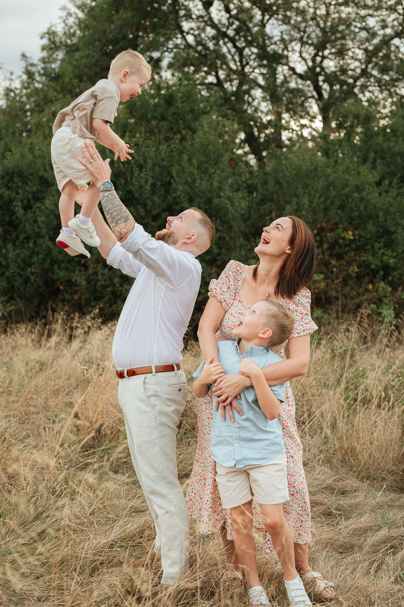 Family of four enjoying a relaxed outdoor moment together at sunset in Tadpole Garden Village.