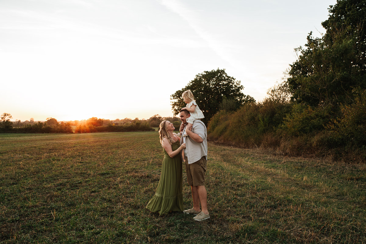 Family photography in an open field during sunset