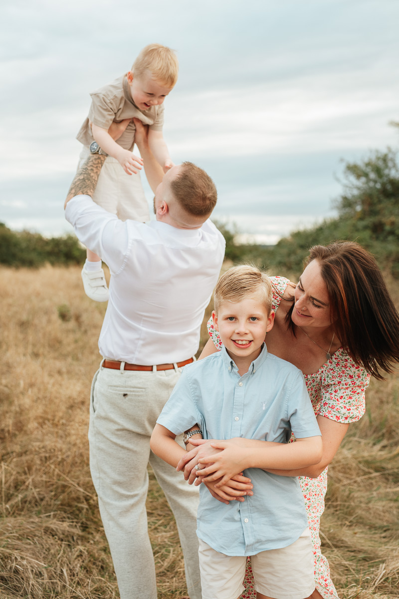 Family of four enjoying a relaxed outdoor moment together at sunset in Tadpole Garden Village.
