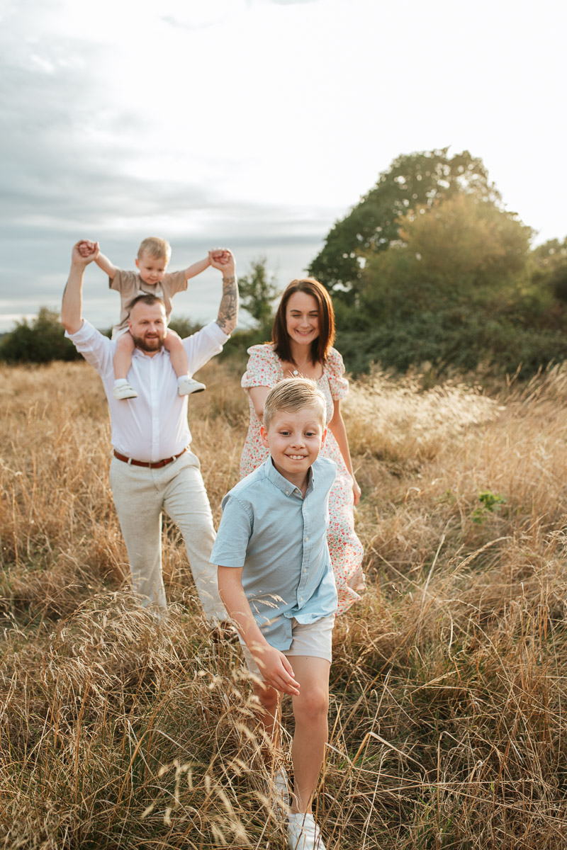 family of four walking through the long grass in the fields at tadpole garden village