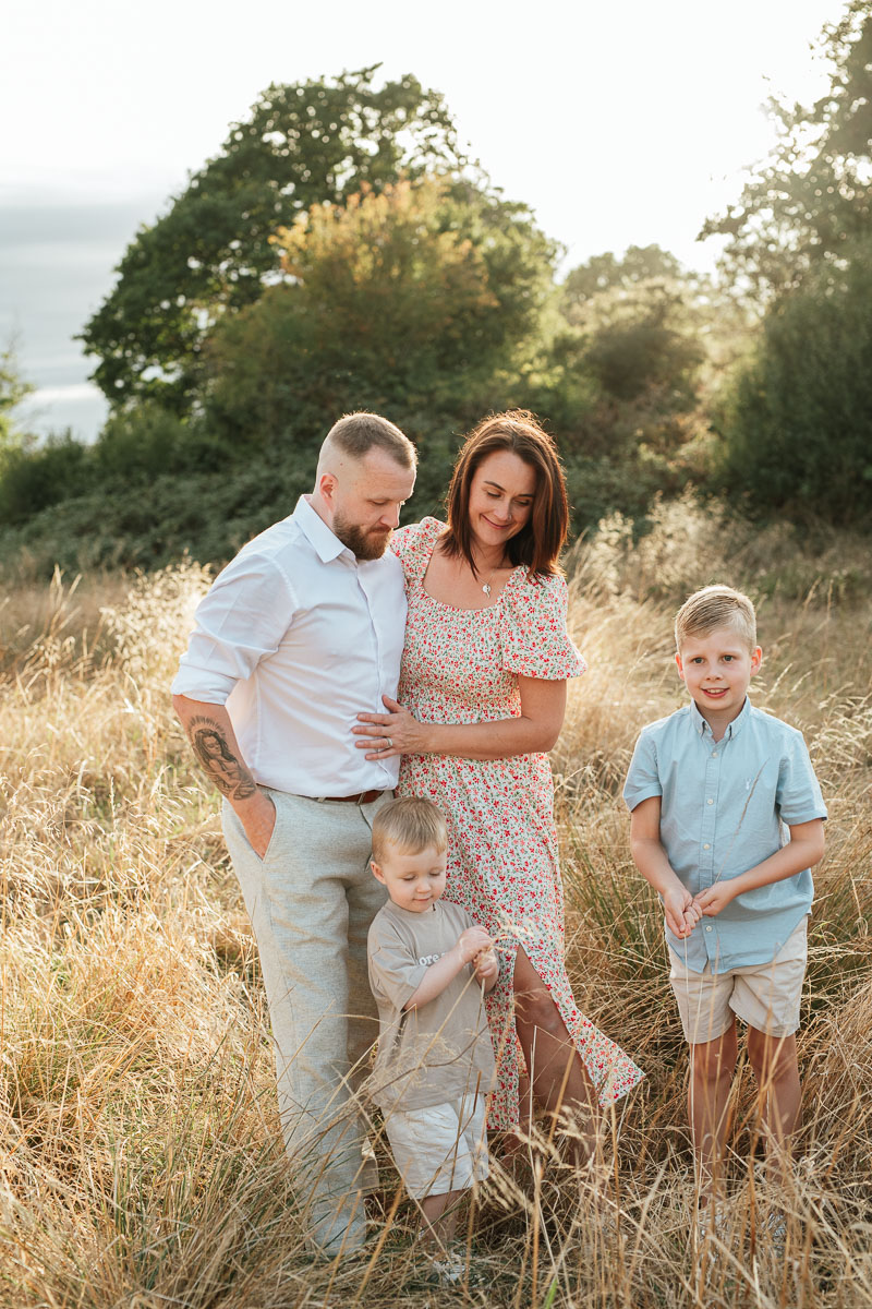 Family of four enjoying a relaxed outdoor moment together at sunset in Tadpole Garden Village.