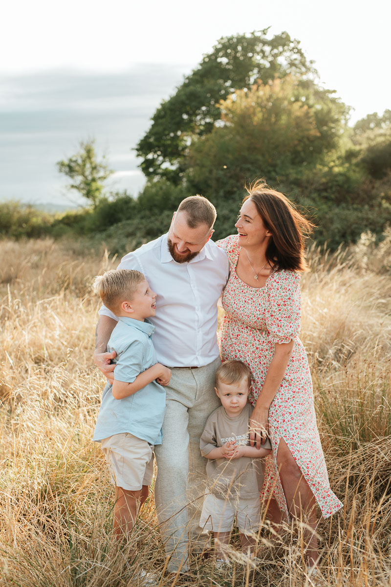 Family of four enjoying a relaxed outdoor moment together at sunset in Tadpole Garden Village.