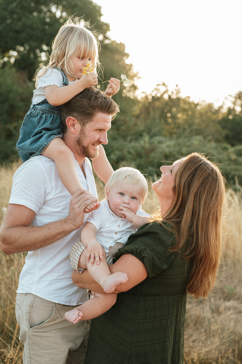 Family of four enjoying a relaxed outdoor moment together at sunset in Tadpole Garden Village.